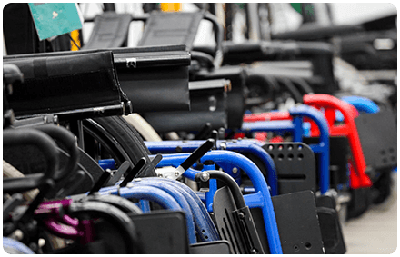 rocky bay's professionally cleaned second hand wheelchairs are lined up are red, black and/or blue.