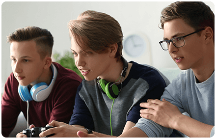 three teenage boys play video games together.