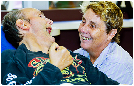 a rocky bay disability support worker and a client smile together in shared disability housing.