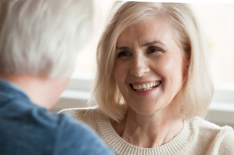 Happy smiling grey haired woman talking to another person
