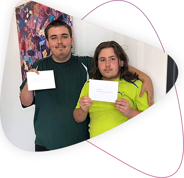 Brothers Ryan and Klive standing next to each and holding their gift vouchers from The Wishing Tree