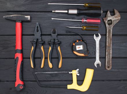 a black wooden table has a range of tools displayed on it.