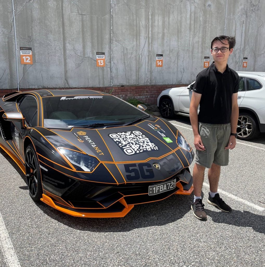 Alex standing in front of a Pentanet branded sports car