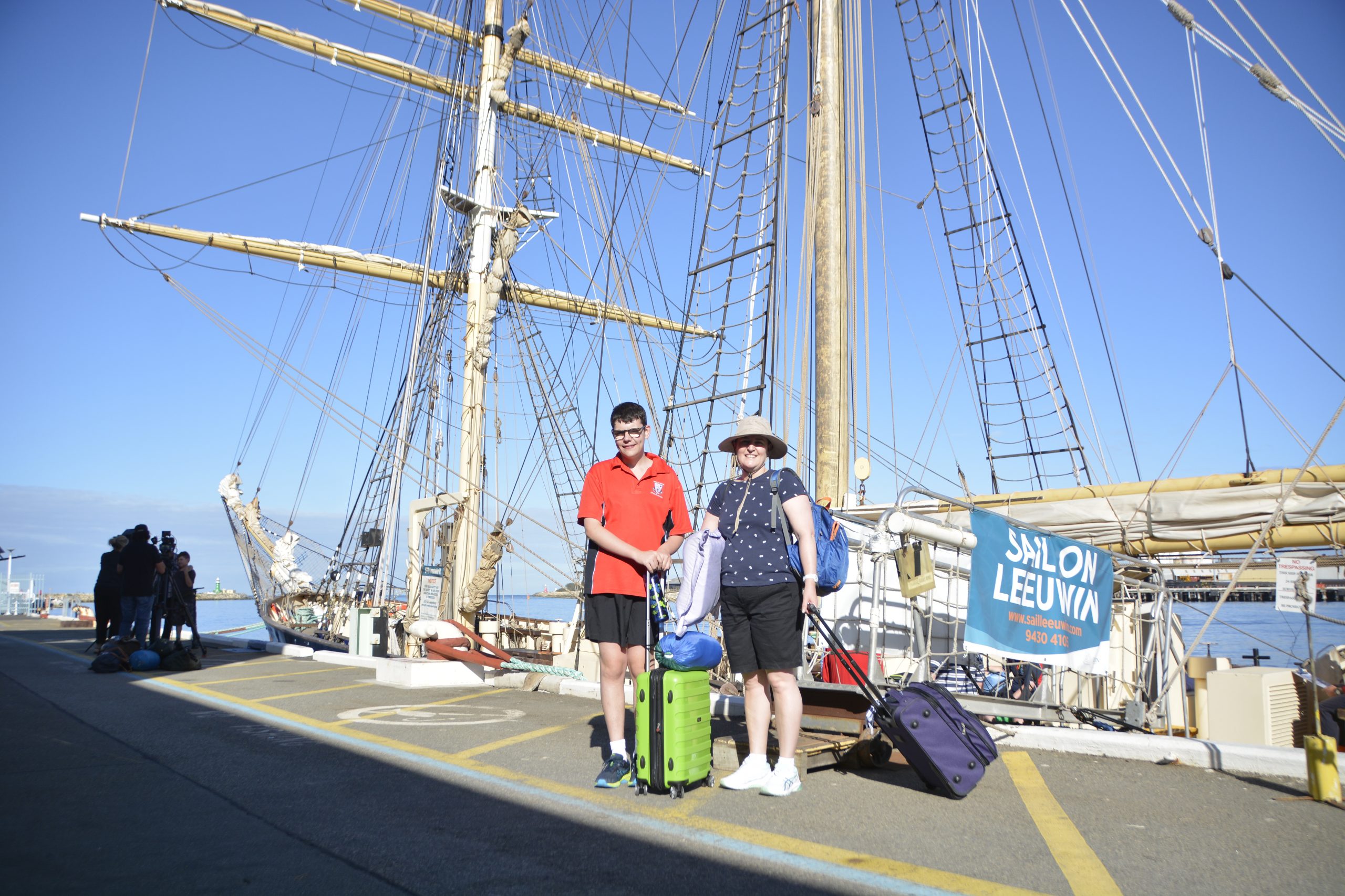Daniel and Julie-Anne stand in front of the Leeuwin after disembarking with their luggage