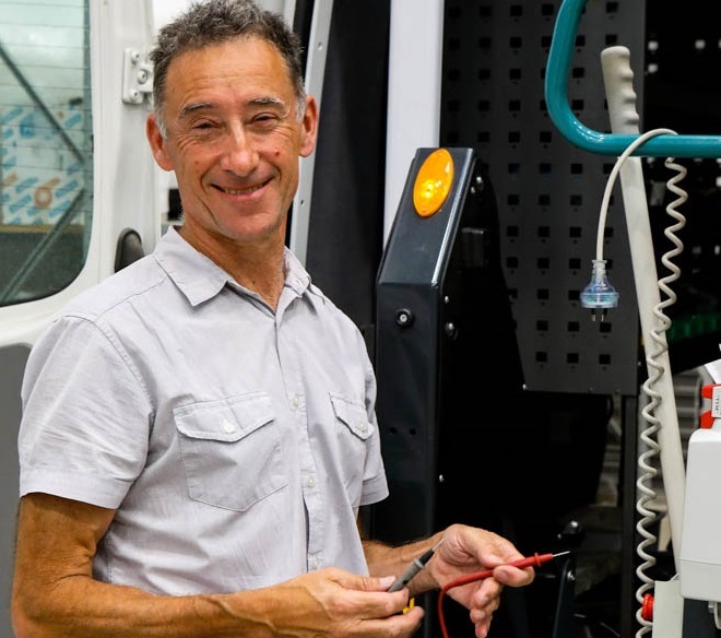 Mark is standing in front of an open Rocky Bay maintenance van