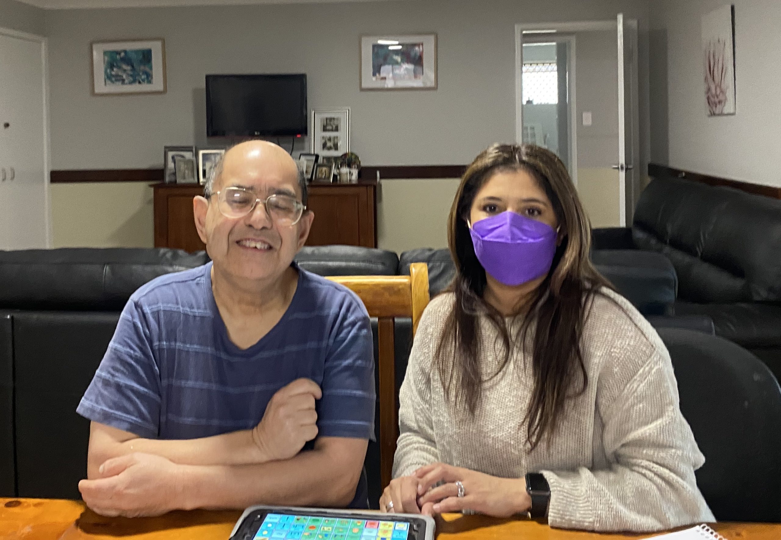 Support worker Illeanna is sitting at a table next to resident James