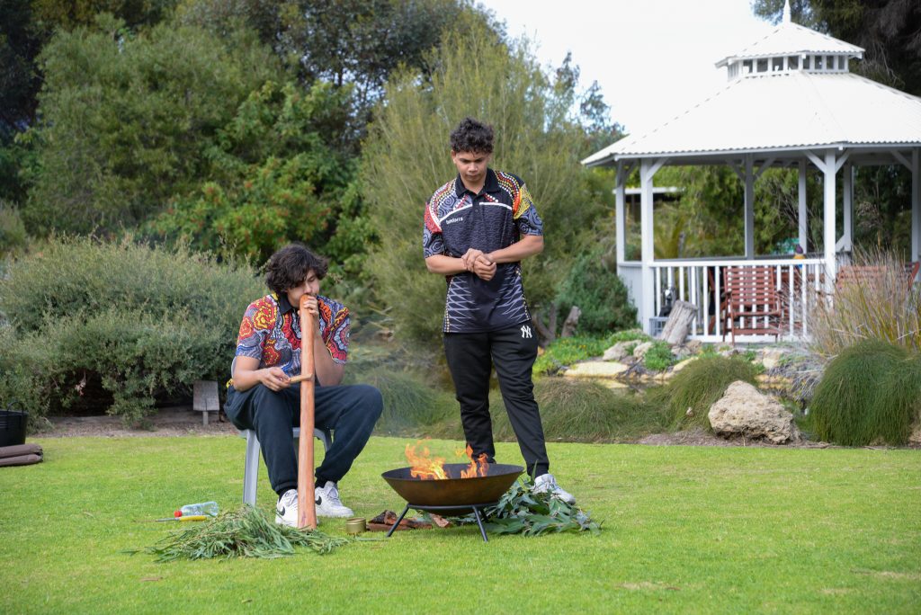 Tryse plays the didgeridoo, and Albert assists with the Smoking Ceremony