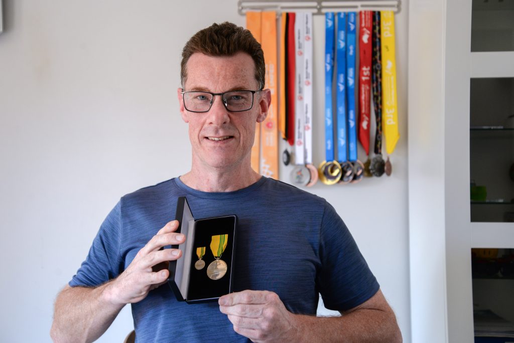 Rocky Bay customer Peter Furnell with his swimming medals.