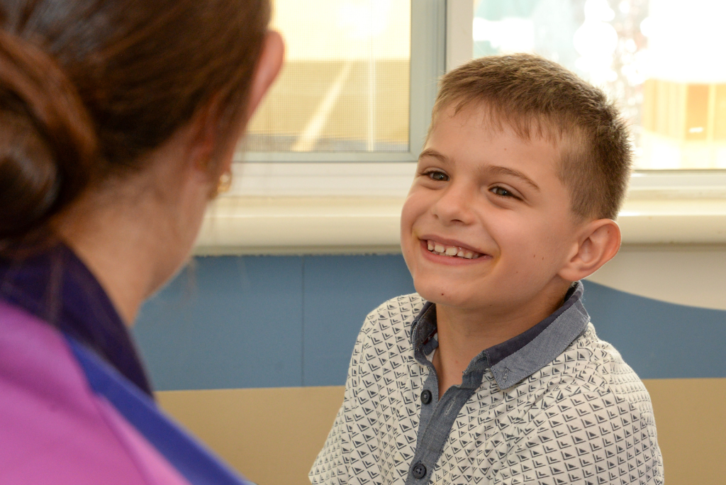 A young boy smiling at the Rocky Bay therapist.