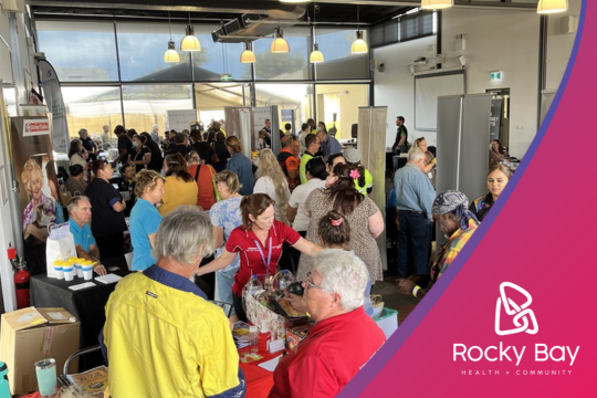 A diverse crowd gathered in a room, engaged in conversation and sharing ideas.