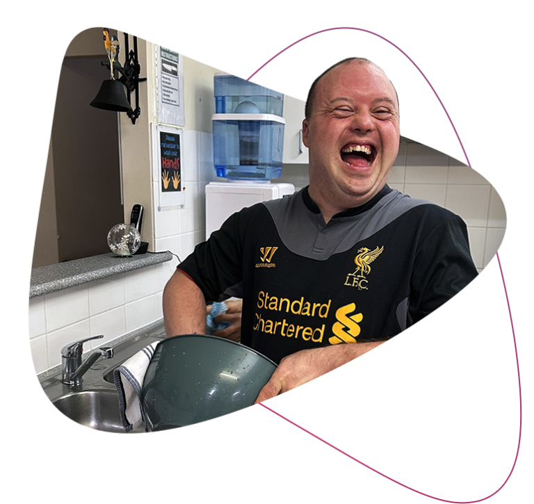 Rocky Bay customer Neil is pictured laughing as he carries out chores in his Supported Accommodation kitchen.