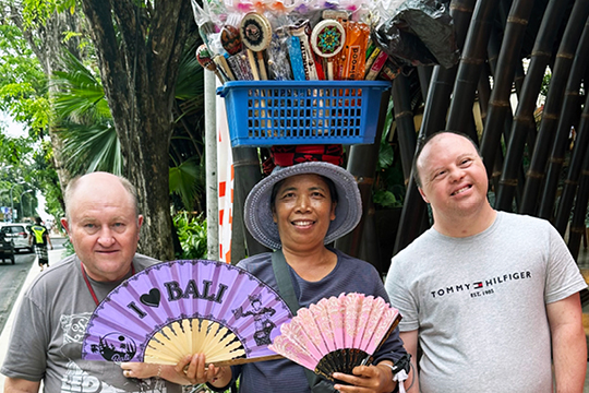 Jason and Neil pose with a Balinese local who is holding fans to sell