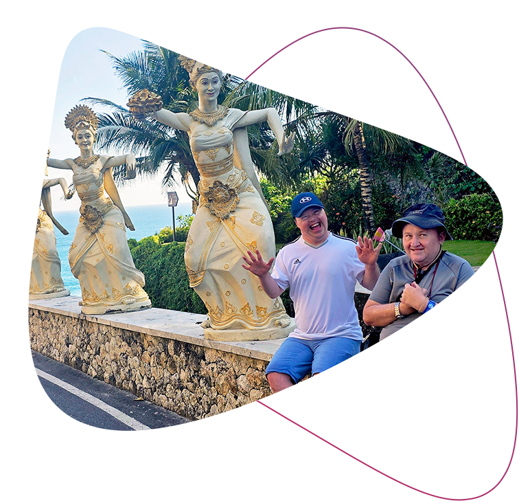 Nei land Jason sit on a stone wall that features traditional Indonesian stone statues of