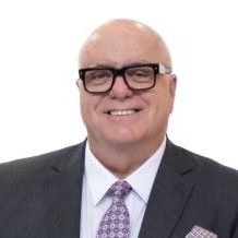Rocky Bay Board Member Trent Bartlett Man in suit with glasses